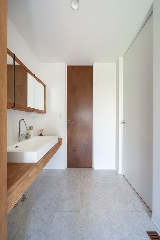 Свежая идея для дизайна: туалет в стиле модернизм с бежевой плиткой, белыми стенами, серым полом, коричневой столешницей и настольной раковиной - отличное фото интерьера