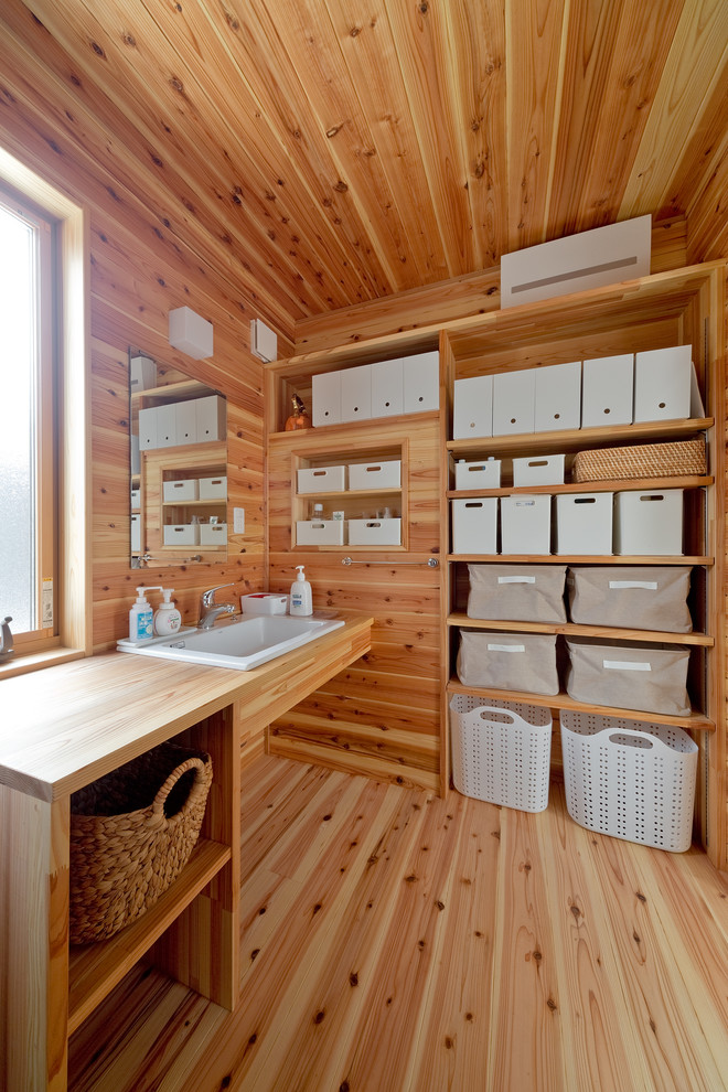 Immagine di un bagno di servizio etnico con pareti marroni, pavimento in legno massello medio e pavimento marrone