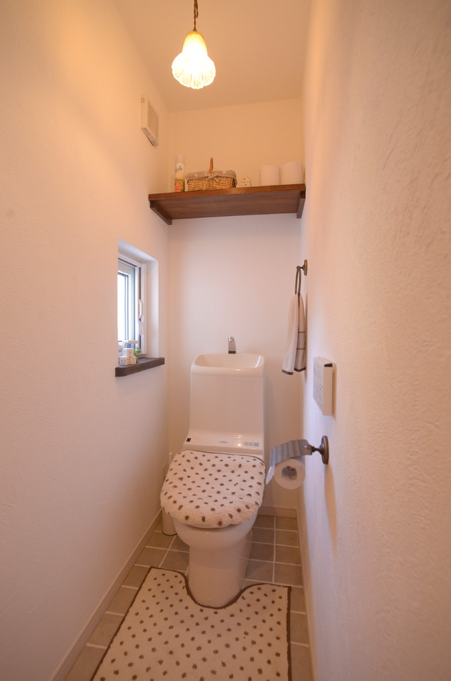 Idee per un bagno di servizio country con WC a due pezzi, pareti bianche e pavimento con piastrelle in ceramica