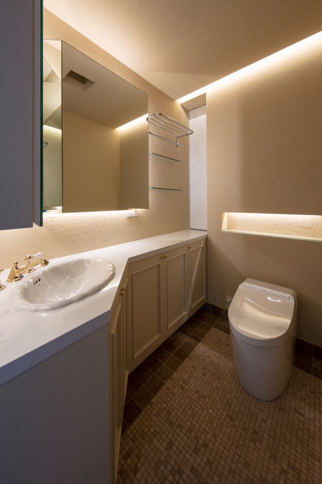 Inspiration för klassiska toaletter, med luckor med upphöjd panel, beige skåp, beige väggar, ett nedsänkt handfat och grått golv