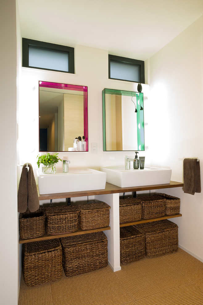 他の地域にあるコンテンポラリースタイルのおしゃれなトイレ・洗面所 (オープンシェルフ、白い壁、ベッセル式洗面器、木製洗面台、茶色い床、ブラウンの洗面カウンター) の写真