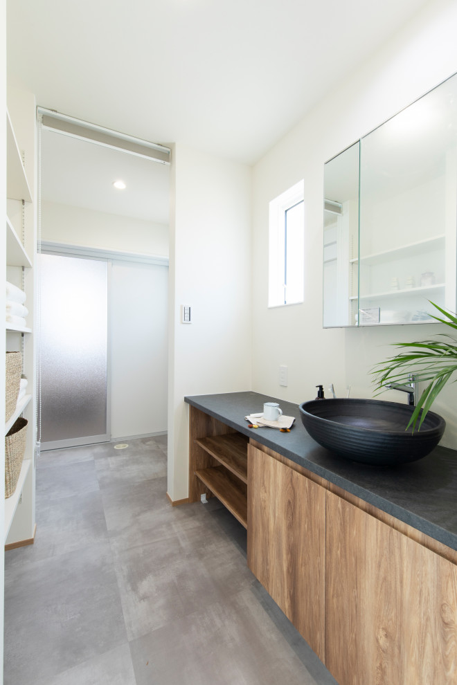 Réalisation d'un WC et toilettes minimaliste en bois brun avec un mur blanc, un sol en vinyl, une vasque, un sol gris, un plan de toilette gris, meuble-lavabo encastré, un plafond en papier peint et du papier peint.