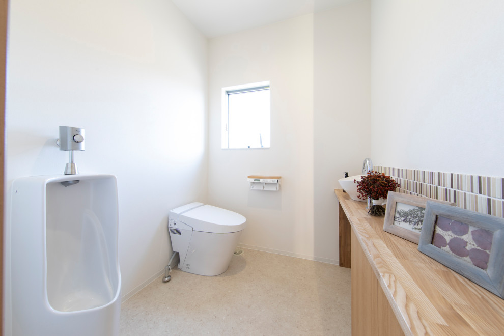 Cette photo montre un WC et toilettes moderne en bois brun avec un urinoir, un carrelage beige, un carrelage en pâte de verre, un plan de toilette en bois, meuble-lavabo encastré et un plafond en papier peint.