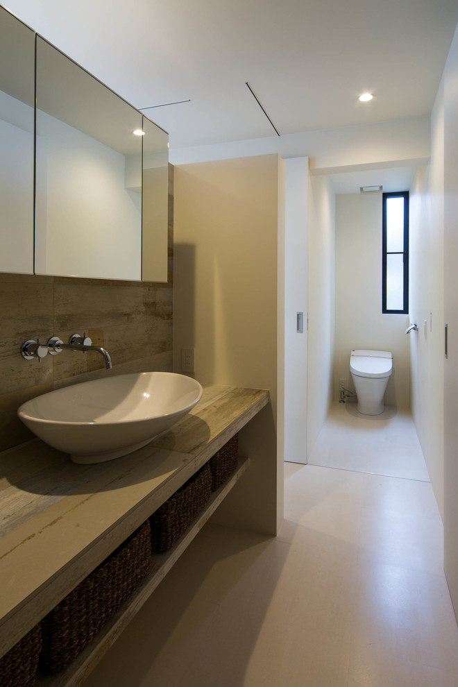 Aménagement d'un WC et toilettes moderne avec un placard sans porte, des portes de placard grises, une vasque et un plan de toilette gris.
