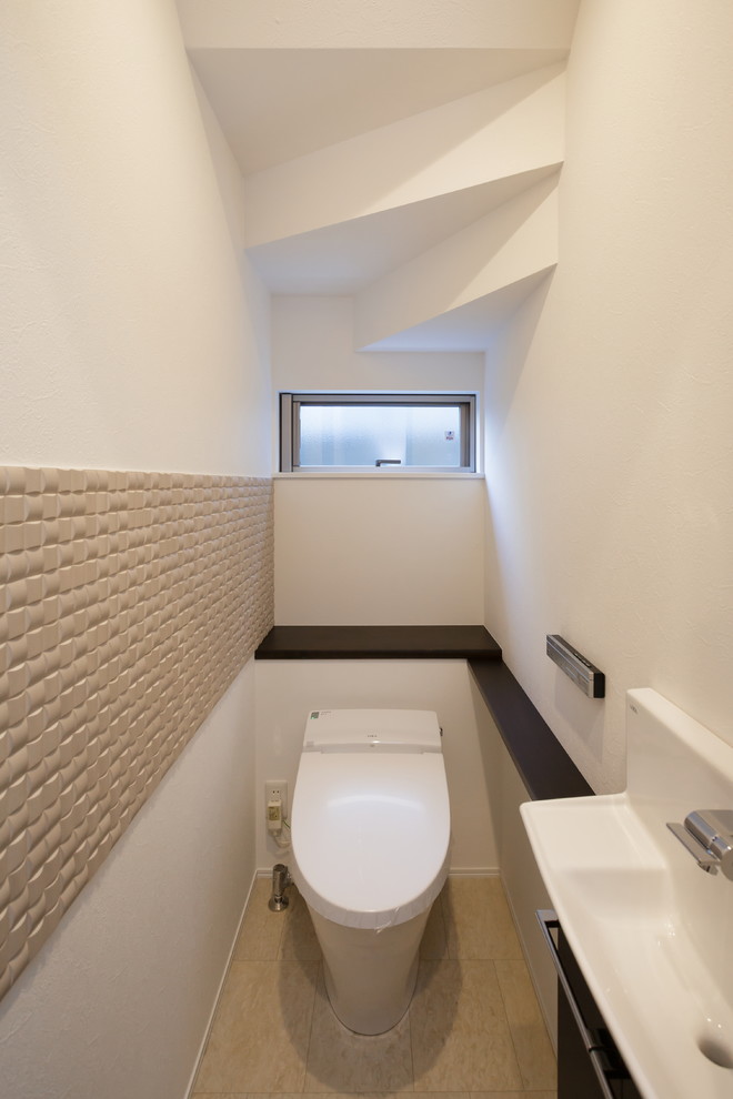 Bild på ett funkis toalett, med vita väggar, ett konsol handfat och beiget golv