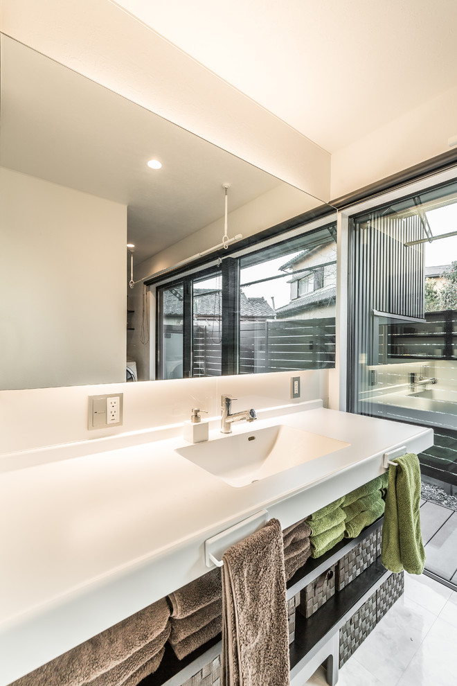 Idee per un bagno di servizio minimalista con nessun'anta, pareti bianche, lavabo integrato e pavimento grigio