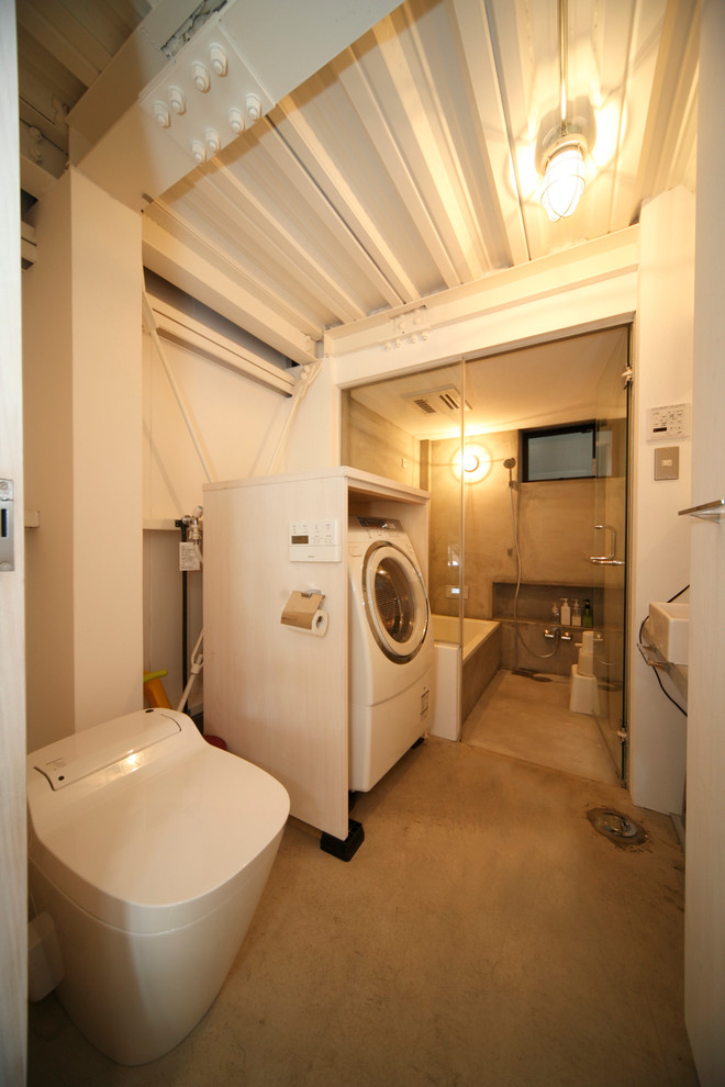 Esempio di un piccolo bagno di servizio minimalista con WC monopezzo, pareti bianche e parquet chiaro