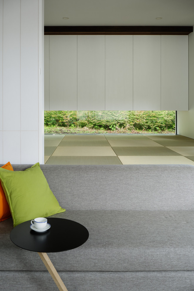 Asiatisk inredning av ett allrum med öppen planlösning, med vita väggar, tatamigolv och grönt golv