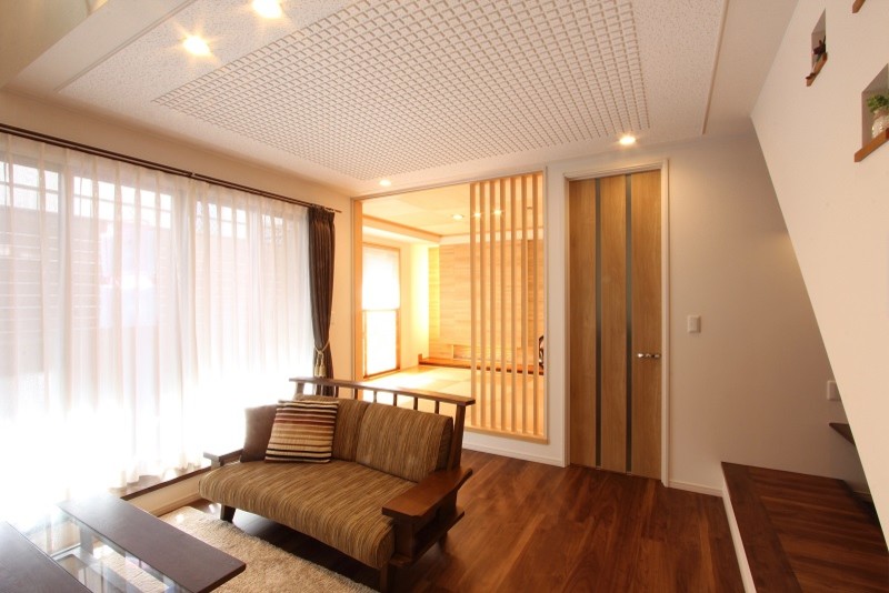 福岡にある広いコンテンポラリースタイルのおしゃれなオープンリビング (白い壁、合板フローリング、据え置き型テレビ、茶色い床) の写真