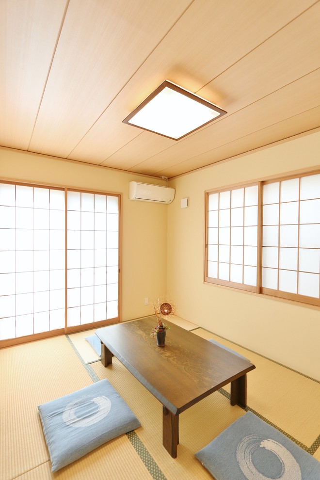 Diseño de comedor asiático con paredes beige, tatami y suelo marrón