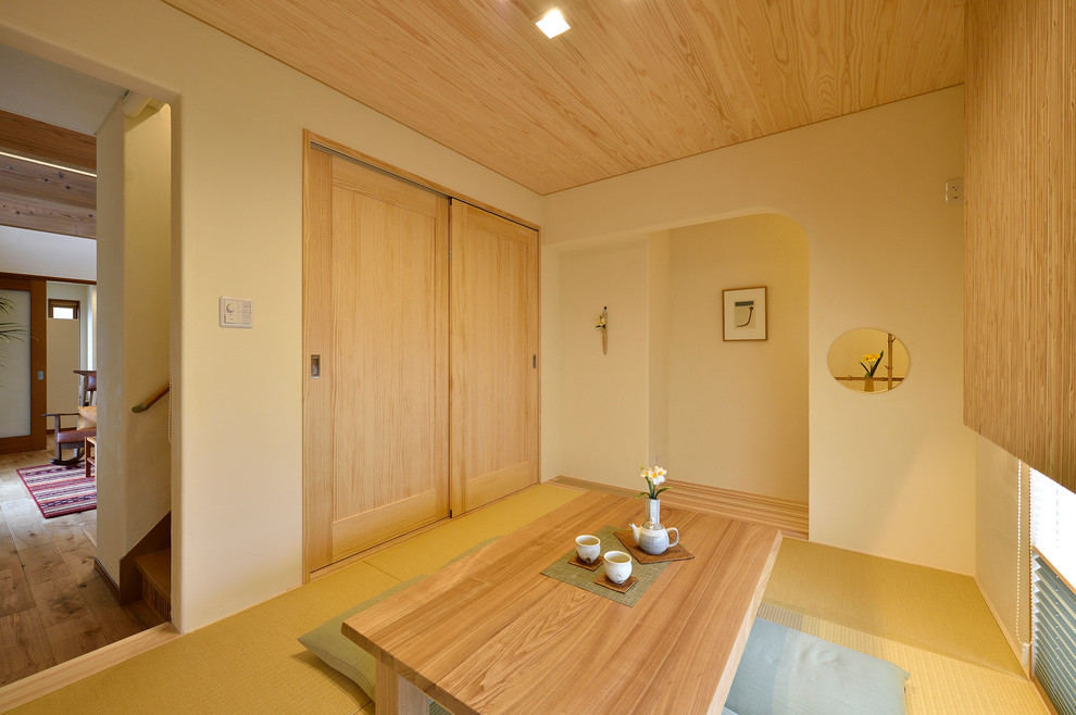 Inspiration pour une salle de séjour asiatique avec un mur blanc, un sol de tatami et un sol marron.