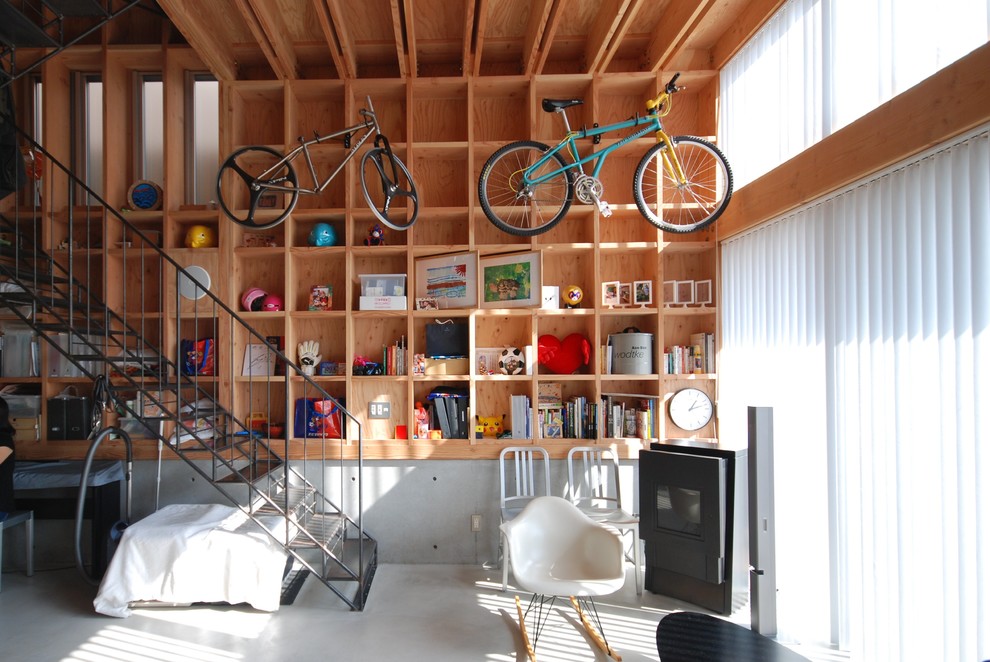 Foto di un soggiorno industriale con libreria, pareti beige e pavimento in cemento