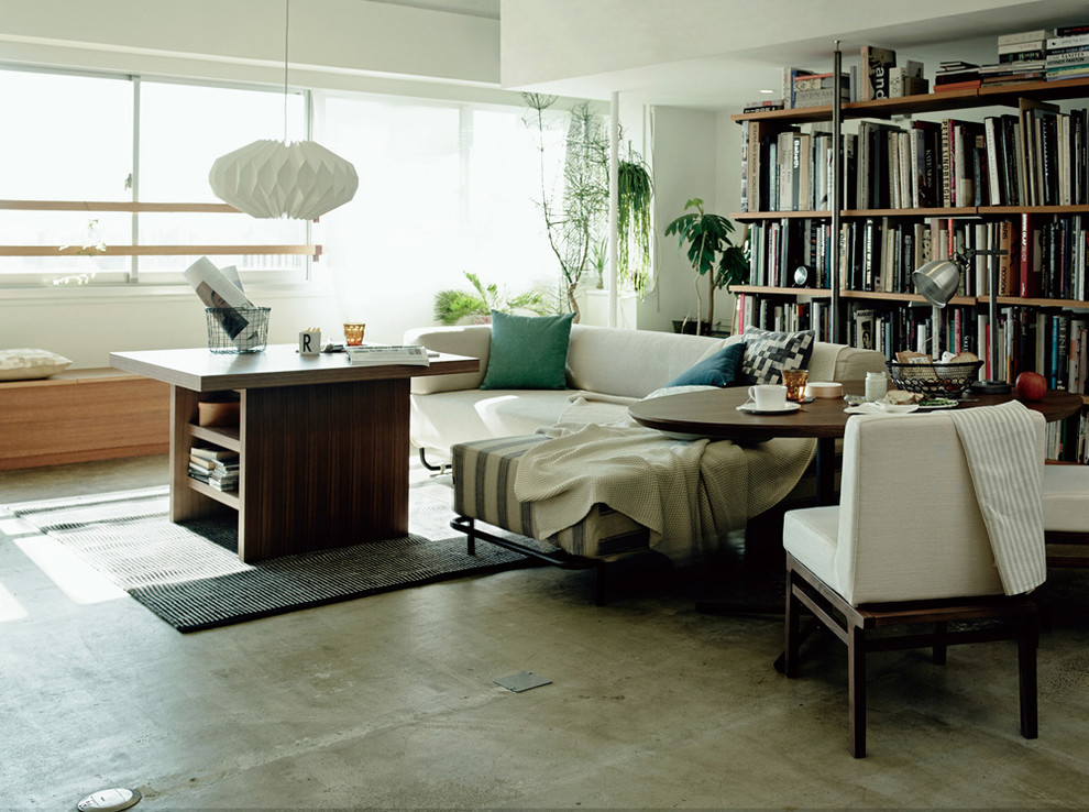 Example of an urban open concept concrete floor and gray floor family room design in Other with white walls