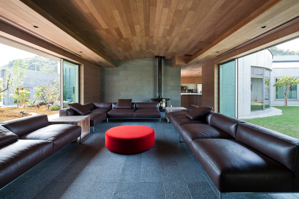 Идея дизайна: большая изолированная гостиная комната в стиле модернизм с разноцветными стенами, стандартным камином, фасадом камина из камня и серым полом