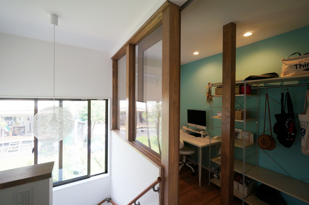 Пример оригинального дизайна: маленькая изолированная гостиная комната в стиле неоклассика (современная классика) с с книжными шкафами и полками, синими стенами, деревянным полом, бежевым полом, потолком с обоями и обоями на стенах без телевизора для на участке и в саду