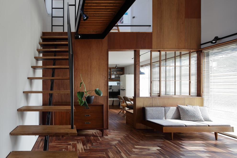 Стильный дизайн: открытая гостиная комната в восточном стиле с белыми стенами, темным паркетным полом и коричневым полом - последний тренд