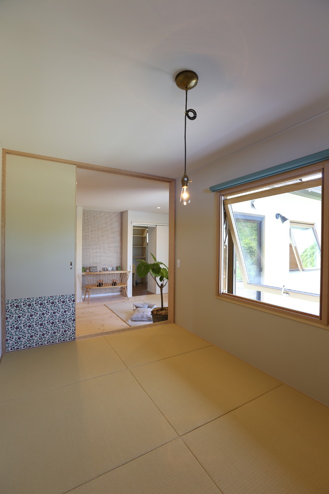 На фото: изолированная гостиная комната в стиле шебби-шик с белыми стенами, татами и бежевым полом без камина