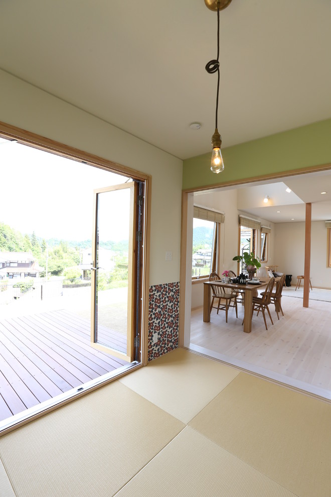 Cette photo montre une salle de séjour scandinave fermée avec un mur vert et un sol de tatami.