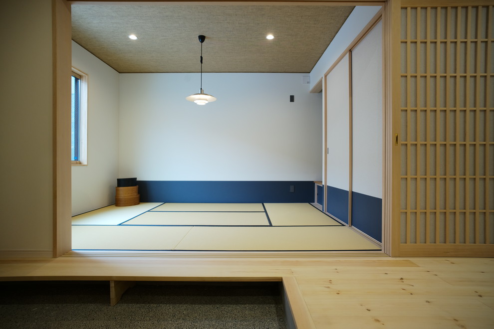 Cette photo montre une salle de séjour asiatique fermée avec un mur multicolore, un sol de tatami, aucune cheminée et un sol beige.