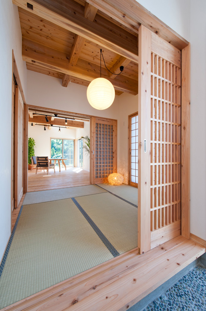 Imagen de sala de estar de estilo zen con paredes blancas, tatami y suelo verde