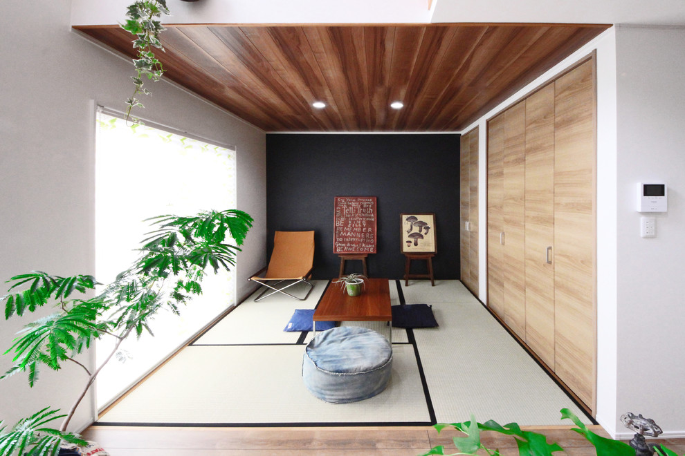 Exemple d'une salle de séjour asiatique fermée avec un mur noir, un sol de tatami et un sol vert.