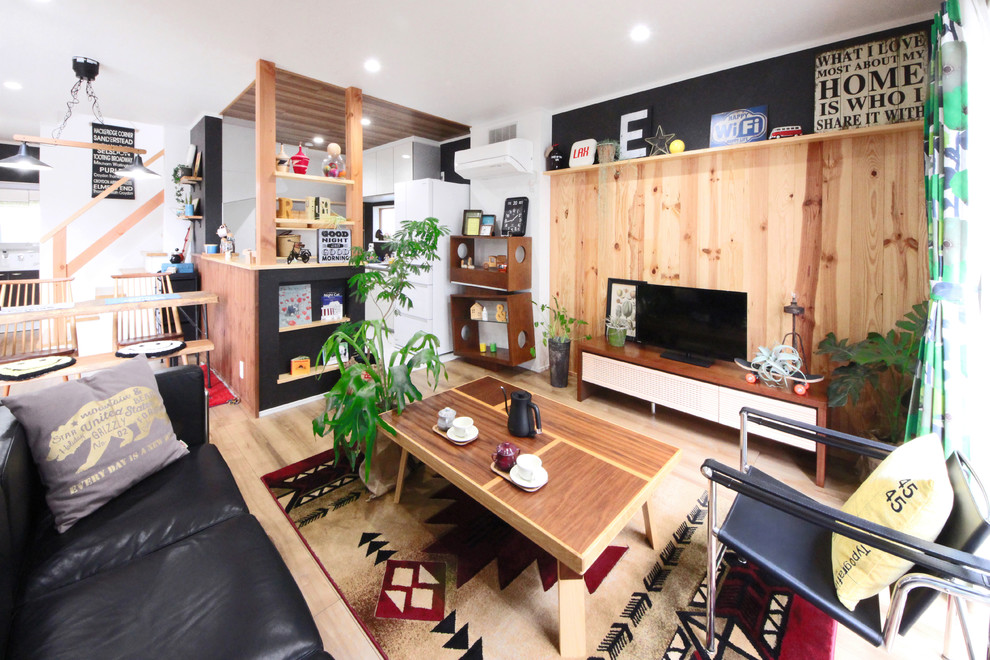 Aménagement d'une salle de séjour industrielle avec un mur multicolore, parquet clair, un téléviseur indépendant et un sol marron.