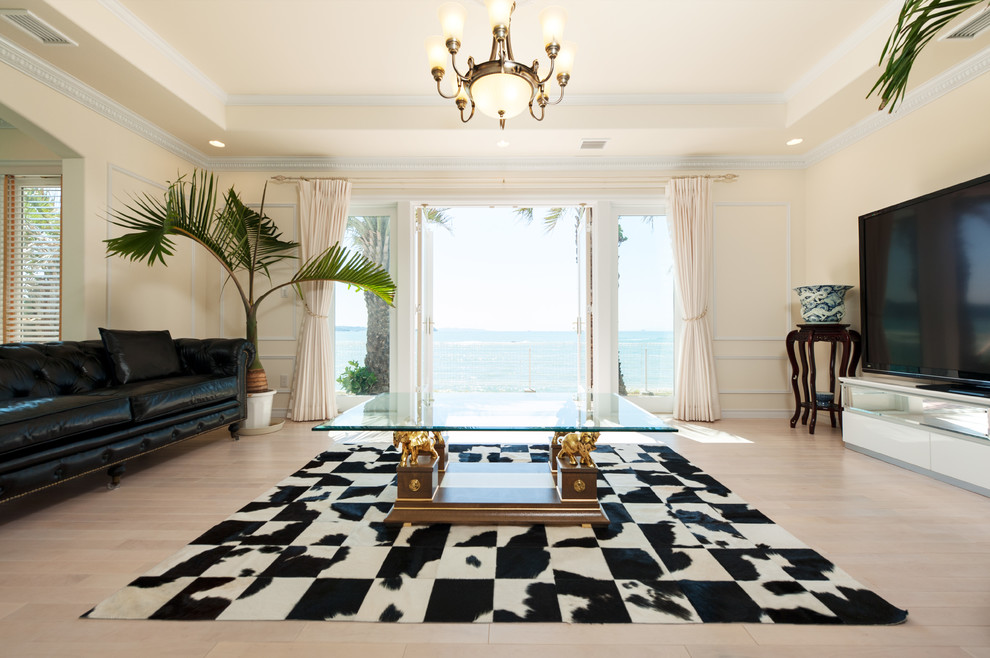 Immagine di un soggiorno mediterraneo con pareti beige, pavimento in legno verniciato, TV autoportante e pavimento beige