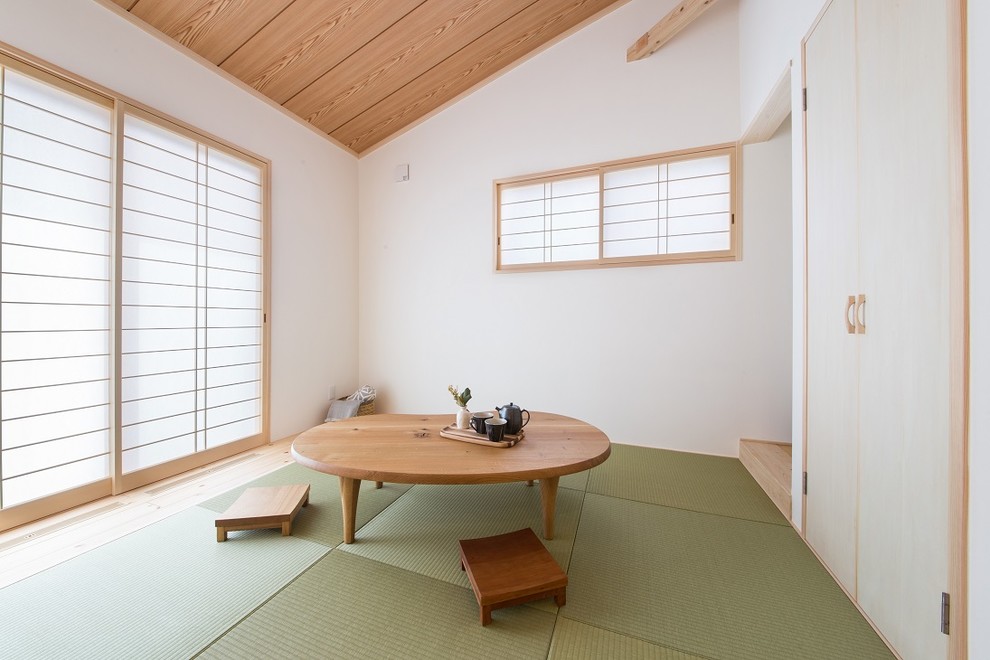 Immagine di un soggiorno etnico con pareti bianche, pavimento in tatami e pavimento verde