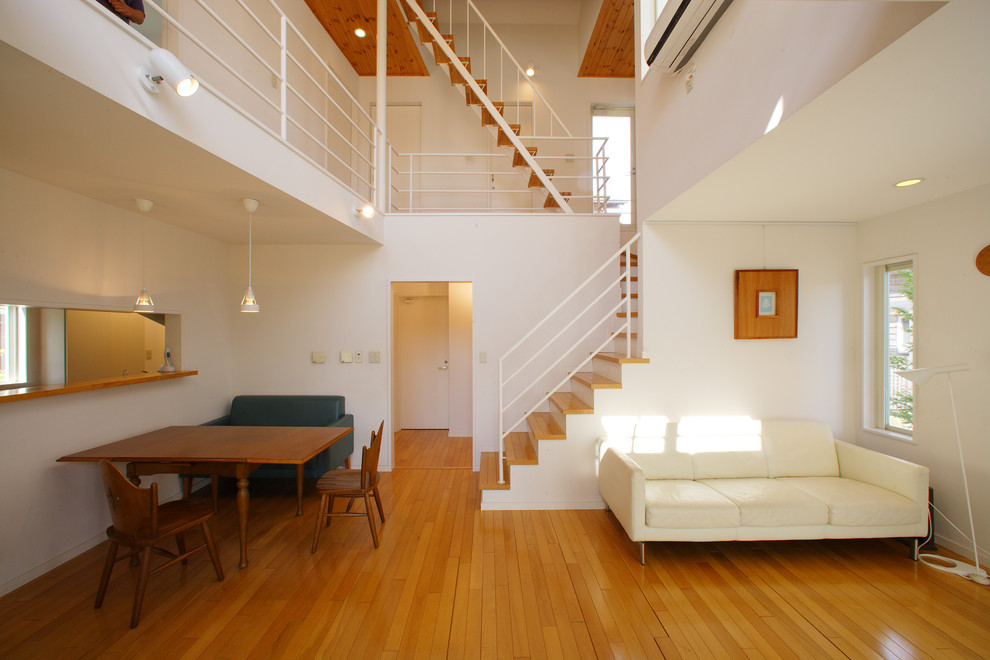 Ispirazione per un soggiorno etnico aperto con pareti bianche, pavimento in legno massello medio e pavimento marrone