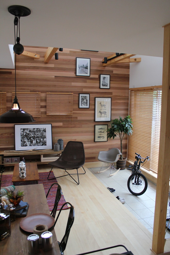 Industrial games room in Other with multi-coloured walls, light hardwood flooring and brown floors.