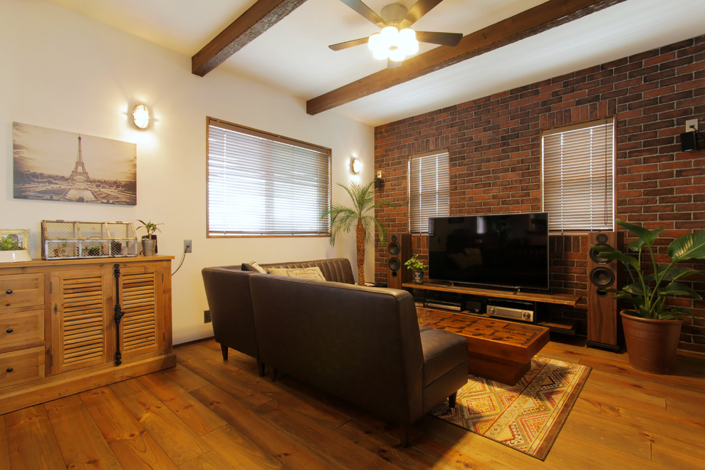 Стильный дизайн: гостиная комната в восточном стиле с белыми стенами, паркетным полом среднего тона, отдельно стоящим телевизором и коричневым полом - последний тренд