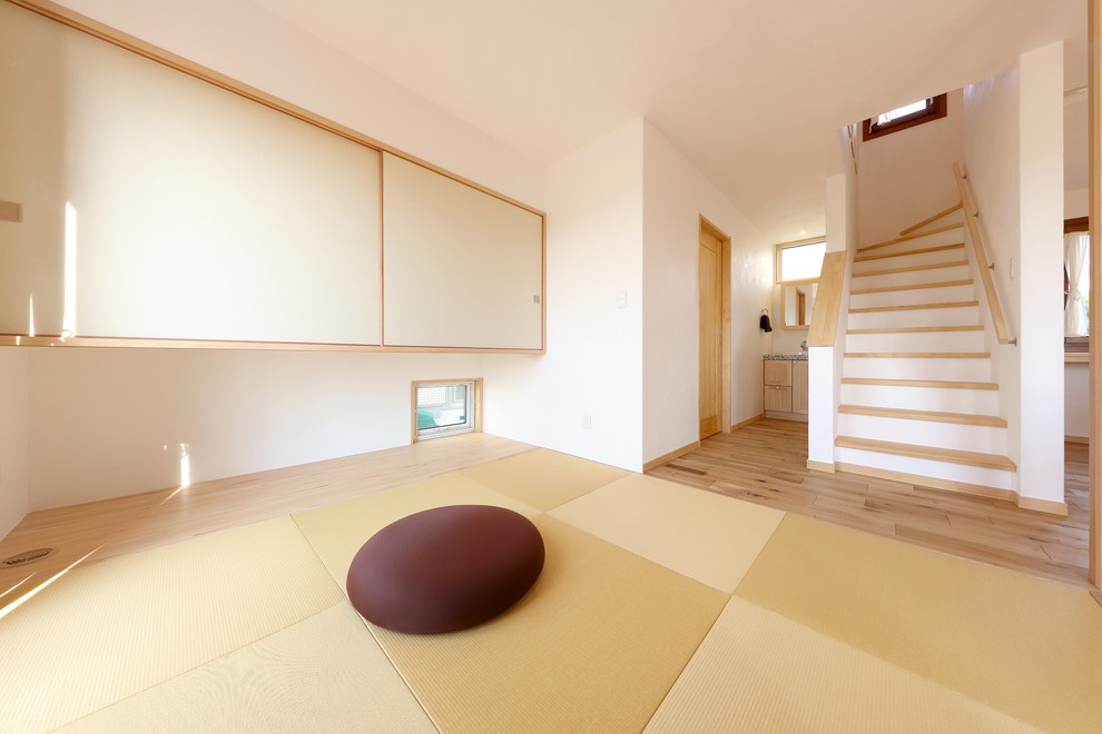 На фото: гостиная комната в средиземноморском стиле с белыми стенами, татами, зеленым полом и отдельно стоящим телевизором без камина с