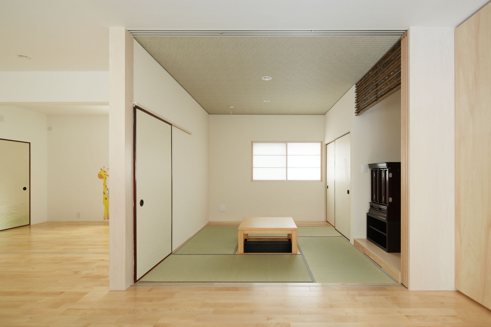 Ejemplo de sala de estar cerrada asiática de tamaño medio sin chimenea y televisor con paredes beige