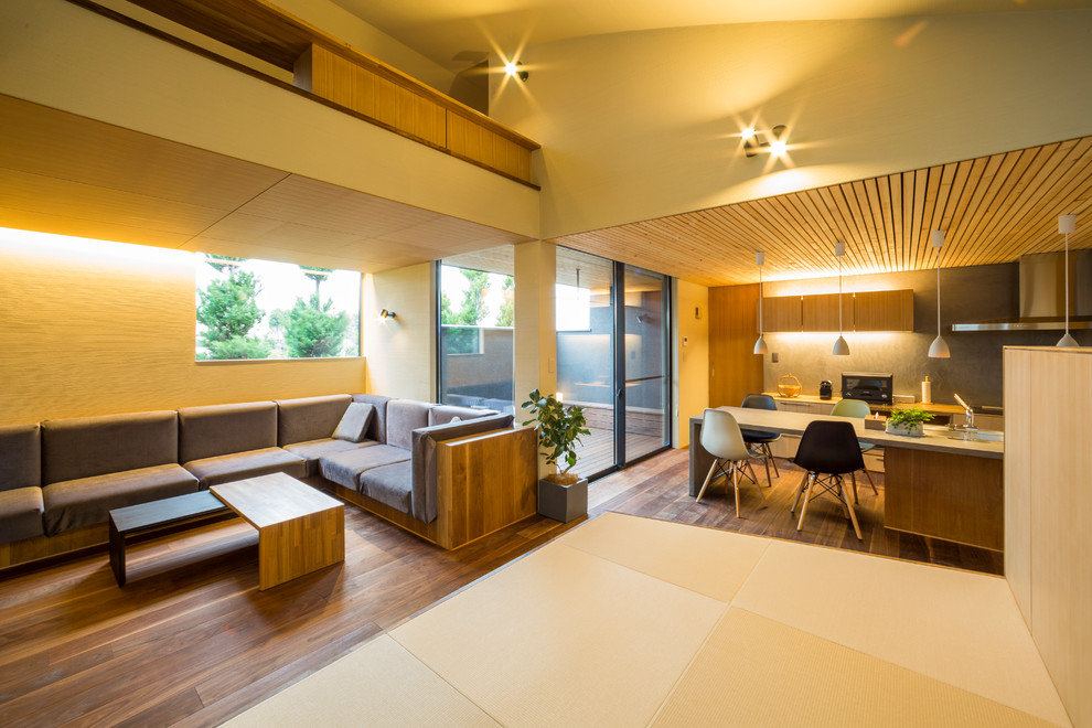 Esempio di un soggiorno moderno aperto con pareti beige, parquet scuro e pavimento marrone