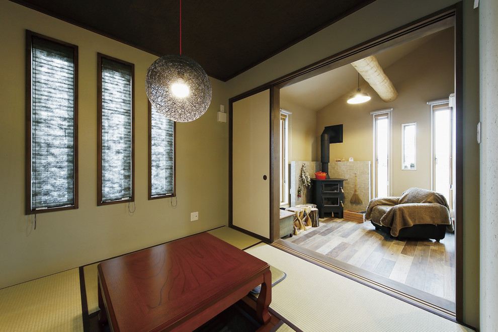 Идея дизайна: маленькая гостиная комната в восточном стиле с зелеными стенами, татами, печью-буржуйкой, фасадом камина из камня и зеленым полом для на участке и в саду