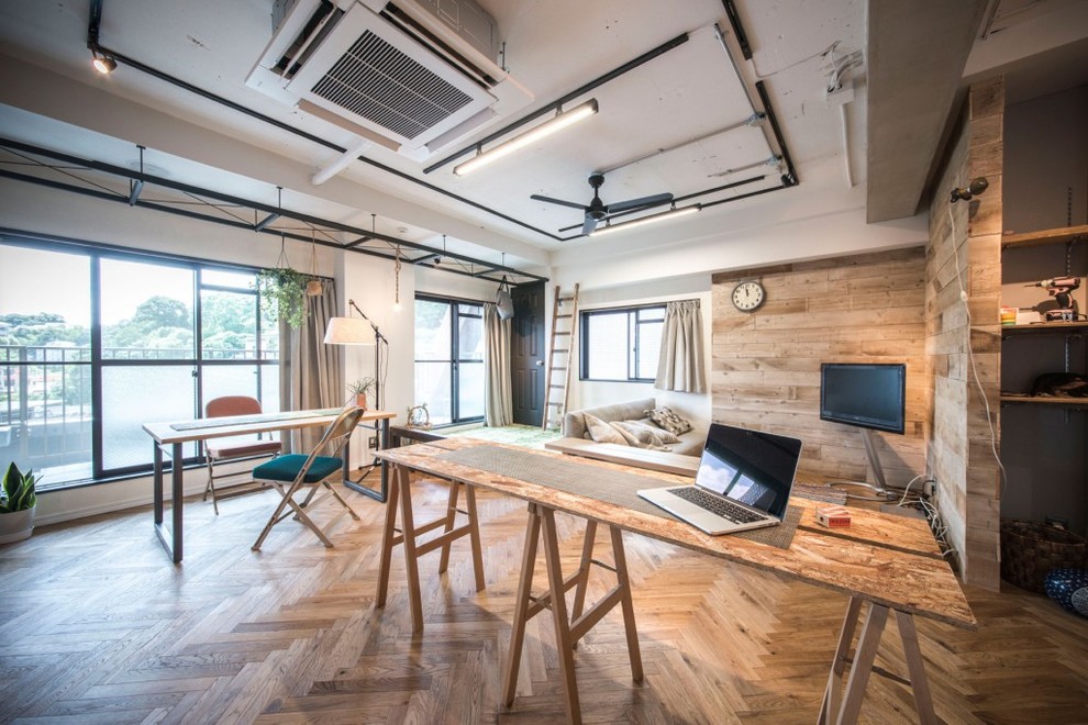 Imagen de sala de estar urbana con paredes multicolor, suelo de madera en tonos medios y televisor independiente