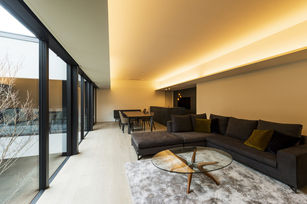 Imagen de sala de estar abierta sin chimenea con paredes beige, suelo de madera clara y suelo blanco