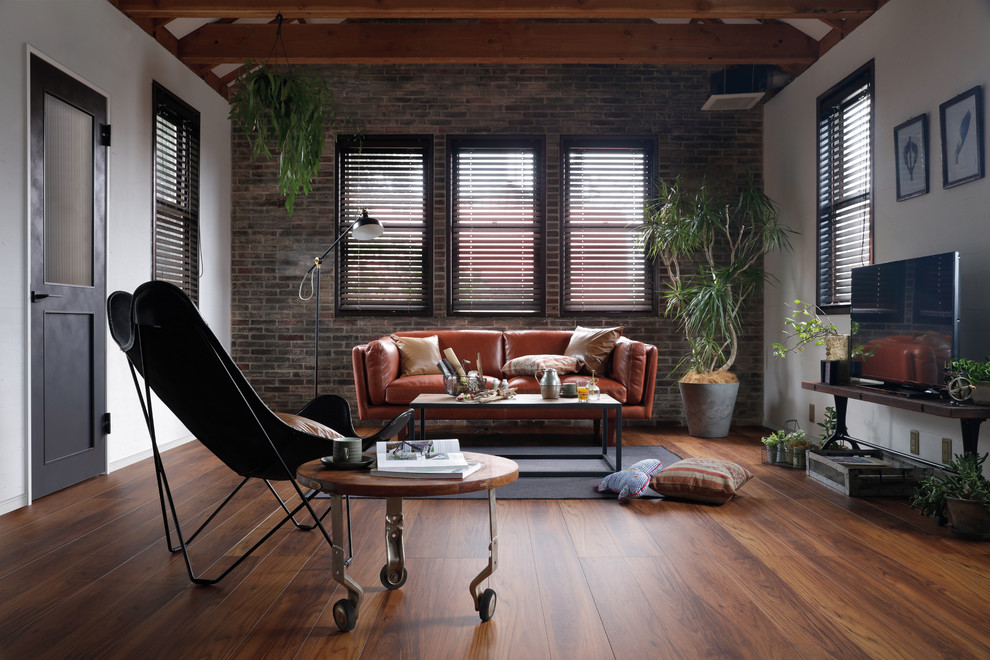 Inspiration for an urban games room in Tokyo with white walls, medium hardwood flooring, a freestanding tv and brown floors.