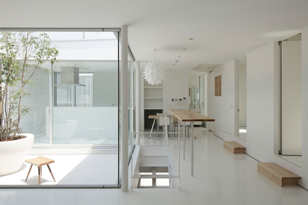 На фото: гостиная комната в стиле модернизм с белыми стенами и белым полом с