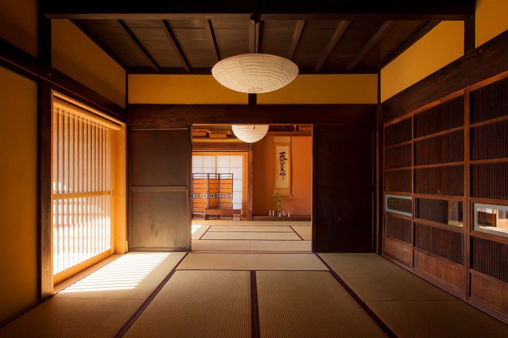 Cette photo montre une grande salle de séjour asiatique fermée avec un mur beige, aucune cheminée, aucun téléviseur et un sol de tatami.