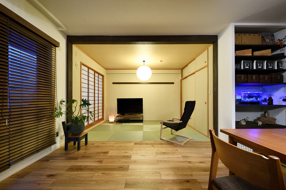 Imagen de sala de estar abierta asiática con paredes blancas y televisor independiente