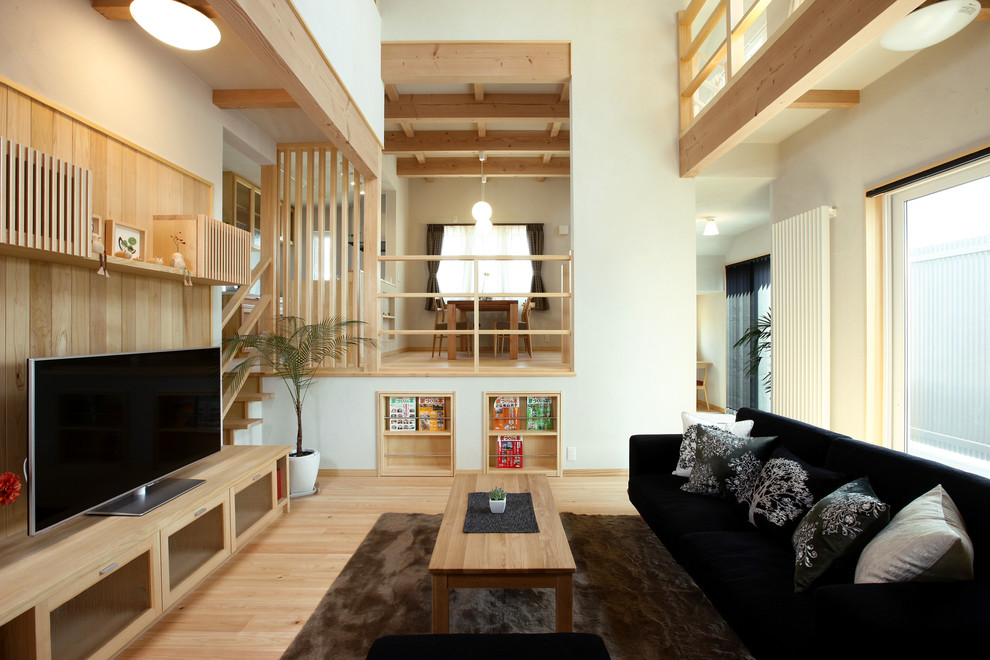 Cette image montre une salle de séjour asiatique ouverte avec un mur blanc, parquet clair, un téléviseur indépendant et un sol beige.
