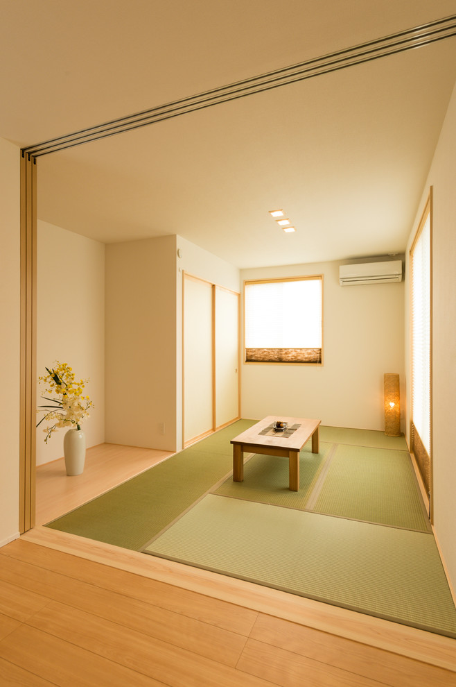 Imagen de sala de estar asiática con paredes blancas, tatami y suelo verde
