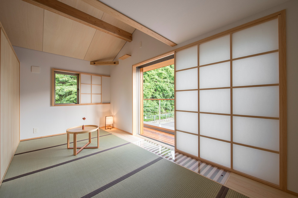 Immagine di un soggiorno etnico chiuso con pareti bianche, pavimento in tatami e pavimento verde