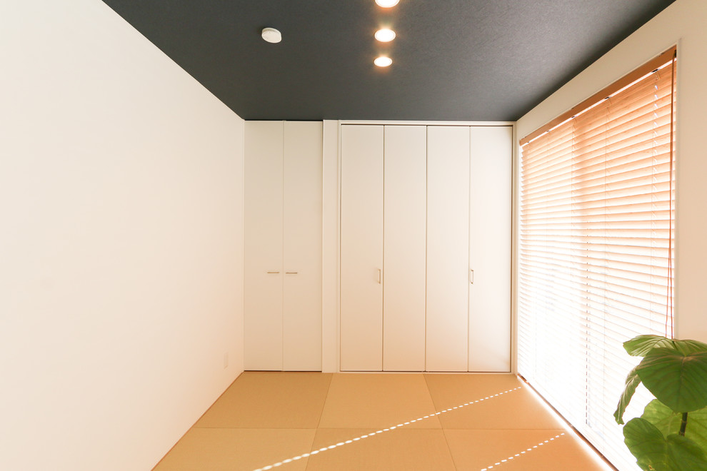 Cette image montre une petite salle de séjour design ouverte avec un mur bleu, un sol de tatami, aucune cheminée, aucun téléviseur et un sol beige.
