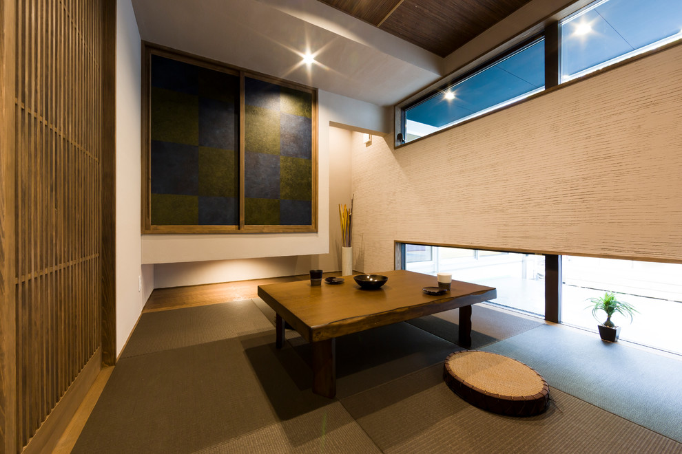 Imagen de sala de estar cerrada asiática con paredes beige, tatami y suelo marrón