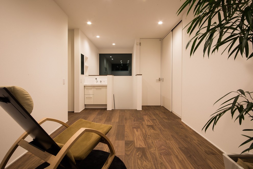 Foto di un soggiorno moderno con pareti bianche, parquet scuro e pavimento marrone