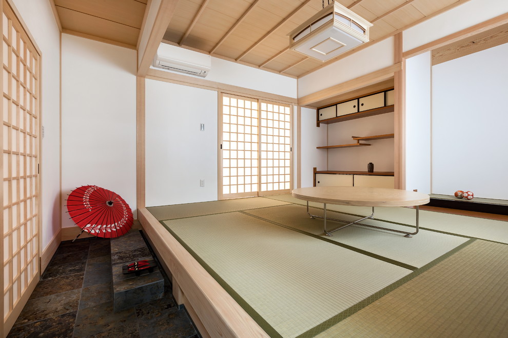 Immagine di un soggiorno etnico con pareti bianche, pavimento in tatami e pavimento verde