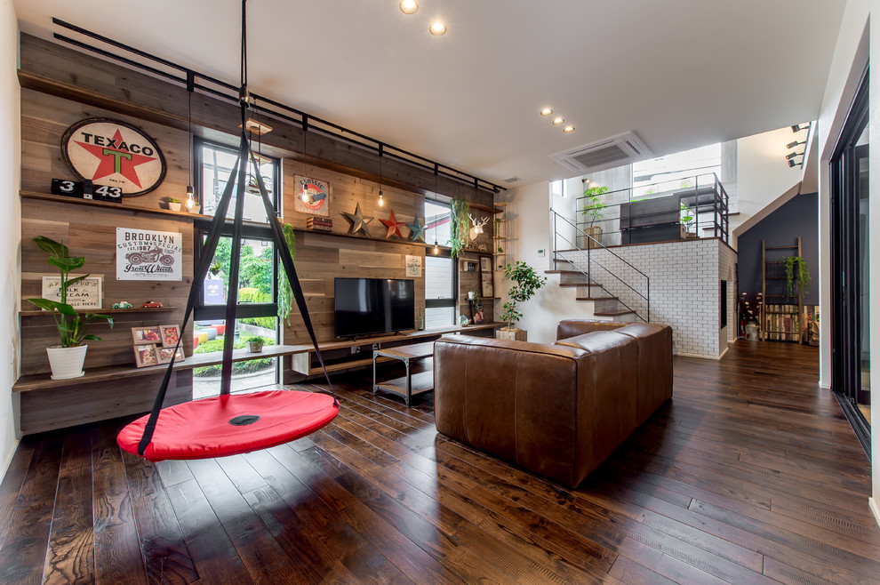 This is an example of an urban games room in Osaka with white walls, dark hardwood flooring, no fireplace, a freestanding tv and brown floors.