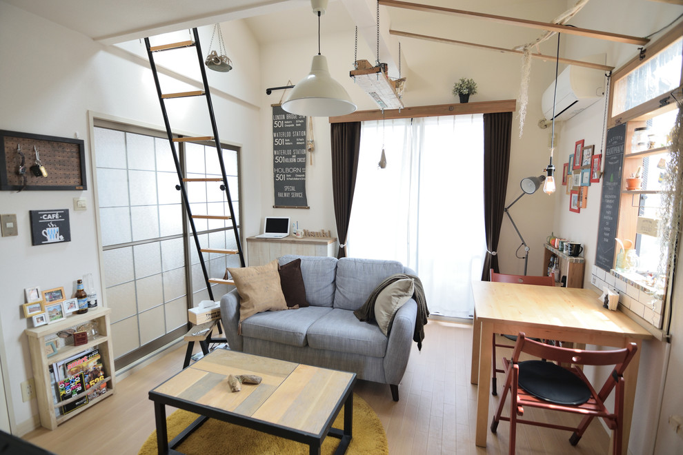 Idee per un piccolo soggiorno industriale con pareti bianche, parquet chiaro e pavimento marrone